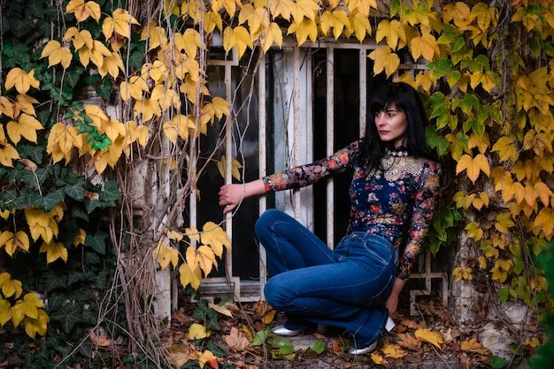 A model wearing a Shein Boho Chic embroidered top with distressed denim jeans, accessorized with a fringed bag and ankle boots.
