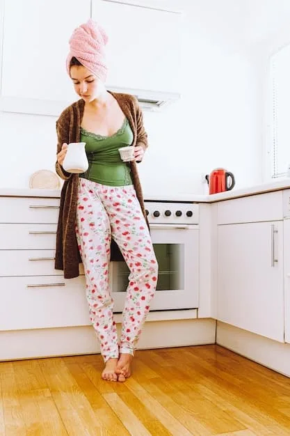 A woman wearing black leggings, a blush pink oversized sweater, and white sneakers. She is carrying a latte and smiling, showcasing a relaxed and stylish athleisure outfit.