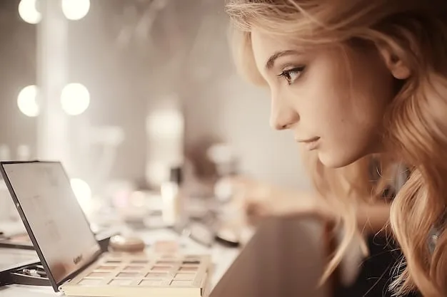 A woman with soft, natural eye makeup using brown eyeshadow and a thin line of eyeliner. The background is a well-lit makeup vanity.