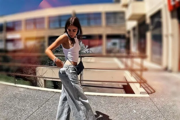 A model wearing sophisticated athleisure attire on a city street, showcasing a mix of high-quality leggings, a designer hoodie, and elegant sneakers. The outfit is accessorized with minimalist jewelry, highlighting how athleisure can be elevated for a fashionable look.