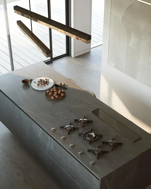 A picture of a sleek, minimalist kitchen with high-end appliances and natural stone countertops. There are no visible brand logos, emphasizing the quality and craftsmanship of the materials.