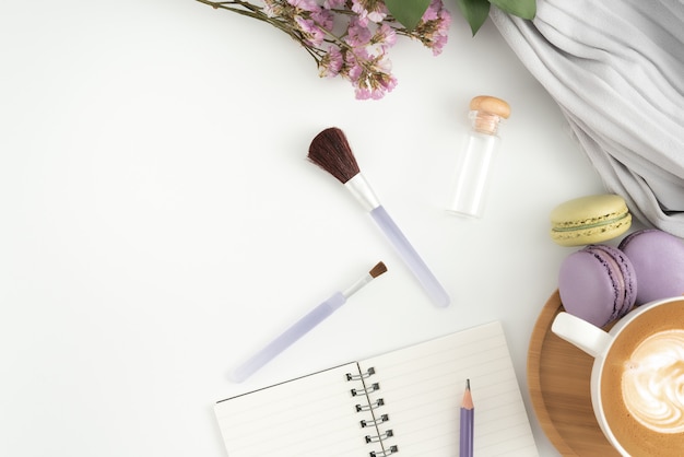 A flat lay of essential makeup products on a clean white surface, including concealer, mascara, blush, and lip gloss, demonstrating the minimalist approach to a 5-minute makeup routine.