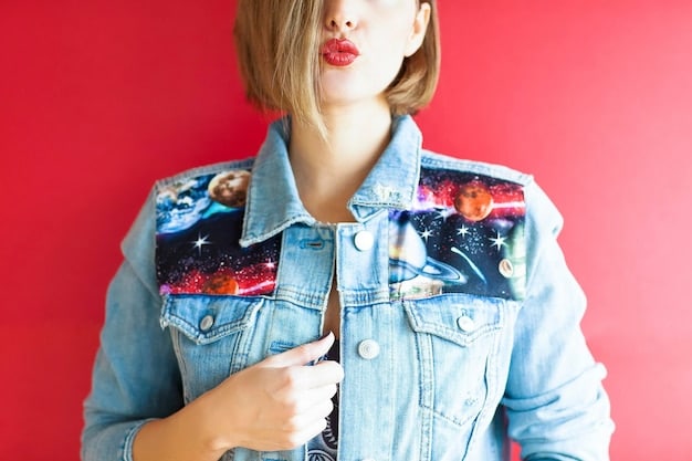 A close-up shot of a woman wearing a denim jacket over a graphic t-shirt, paired with dark wash jeans and ankle boots. The focus is on the layering and the textural contrast between the denim and the t-shirt fabric.