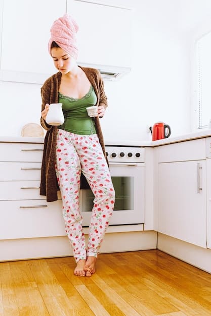 A woman wearing black leggings, a blush pink oversized sweater, and white sneakers. She is carrying a latte and smiling, showcasing a relaxed and stylish athleisure outfit.