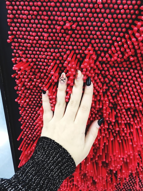 A hand displaying nail art with metallic chrome accents, creating a futuristic and high-gloss finish. The design incorporates subtle geometric patterns for added intricacy.