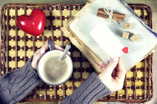 A person writing positive affirmations in a journal, with a cup of tea and a cozy background, symbolizing intentional self-care and positive thinking.