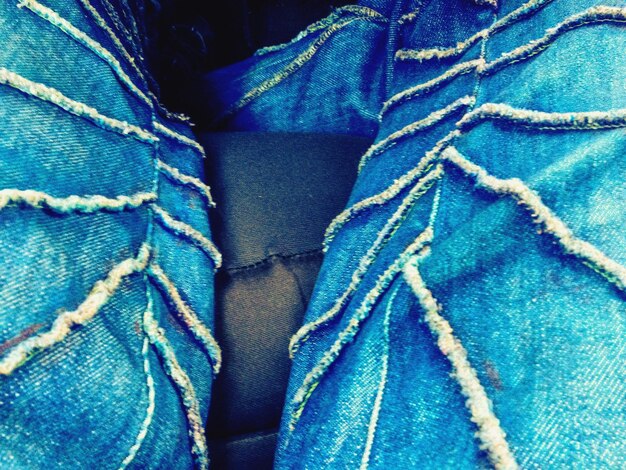 A close-up shot of a garment made from upcycled denim at NYFW 2024, highlighting the intricate patchwork and innovative design that transforms discarded material into high fashion.