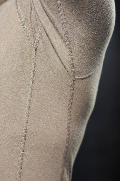 A close-up shot of high-quality athleisure fabric showing texture, stitching, and technical details that offer both comfort and durability. The fabric is a blend of natural and synthetic fibers, highlighting the attention to performance and style.