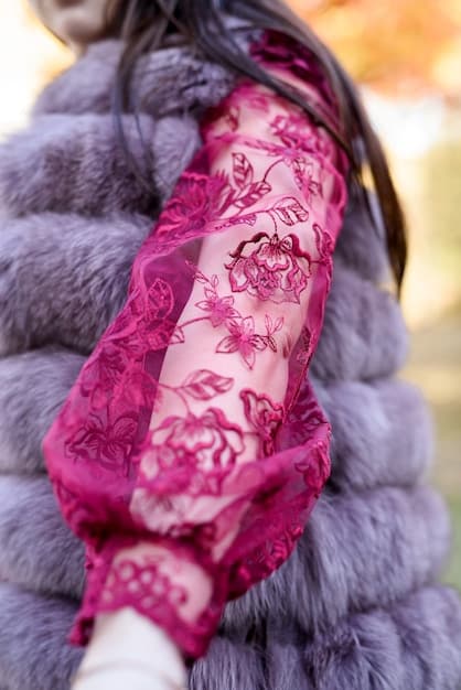 A close-up photograph showcasing various types of statement sleeves: a voluminous puffed sleeve made of sheer fabric, a bell sleeve with intricate embroidery, and a bishop sleeve with delicate ruffles. The image highlights the diverse designs and textures that define statement sleeves