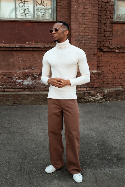 A street-style photo showing a person wearing a minimalist outfit: a simple black turtleneck, straight-leg jeans, and white sneakers, embodying the understated elegance of the trend.