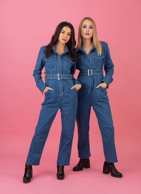 Two people standing side-by-side, both wearing the same style of jumpsuit in different colors. The jumpsuits are simple, functional, and made from durable material. The image highlights the idea of shared styles and breaking down gendered clothing categories.