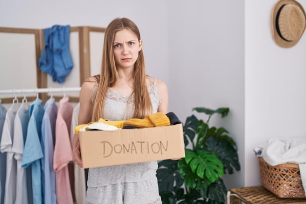 A woman sorting through her clothes, deciding which items to keep, donate, or sell. She has a pile of clothes to keep and a pile of clothes to donate. She is smiling and appears to be enjoying the process.