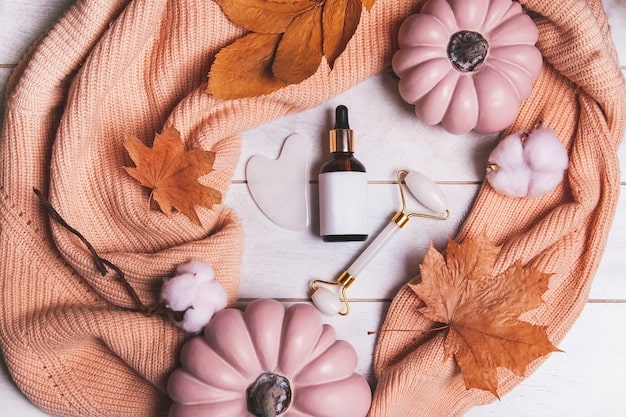 An autumn-themed flat lay featuring a WePink Shein sweater, a scarf in fall colors, a perfume bottle with warm notes, and a scattering of dried leaves and cinnamon sticks.
