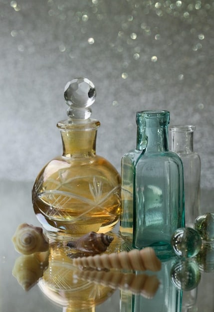 A close-up shot showcasing various perfume bottles, each representing a different fragrance family (floral, oriental, woody, fresh). The bottles are artfully arranged on a modern, minimalist shelf, with soft lighting highlighting their unique shapes and colors.
