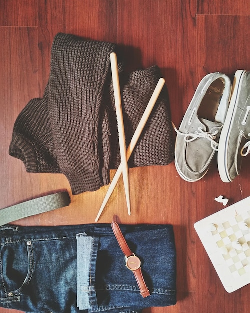 A neatly arranged capsule wardrobe featuring neutral-colored clothing items such as white shirts, black pants, beige sweaters, and a denim jacket.