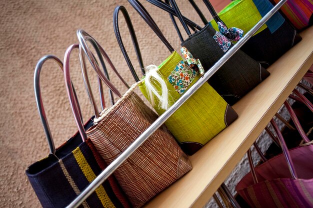 A display in a store featuring a variety of budget-friendly handbags in different styles and colors. The bags are neatly arranged on shelves and mannequins, showcasing their versatility and appeal. The background is a brightly lit retail environment.