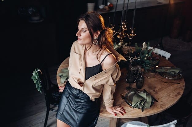 A model in a dimly lit, elegant restaurant, wearing a Shein 'Date Night' Collection outfit. The outfit consists of a shimmering dress, high heels, and statement jewelry. The setting is upscale with soft lighting and luxurious decor.