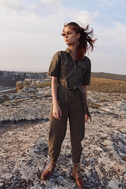 A person wearing a Shein Tencel jumpsuit in olive green, paired with black combat boots and a vegan leather jacket. They are standing in front of a graffiti wall, highlighting the edgy and eco-conscious vibe of the outfit.