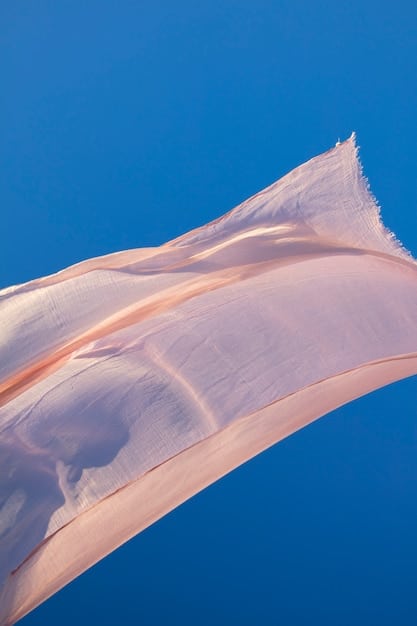 A close-up shot of luxurious, flowing fabric made from recycled ocean plastic, showcasing its soft texture and subtle sheen, draped elegantly to highlight its high-end appeal, with a blurred background of a modern design studio.